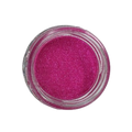 Ein fluoreszierendes Glitter Fuchsia (S0503, 50 ml) in einem Glas auf schwarzem Hintergrund von FLEURY.